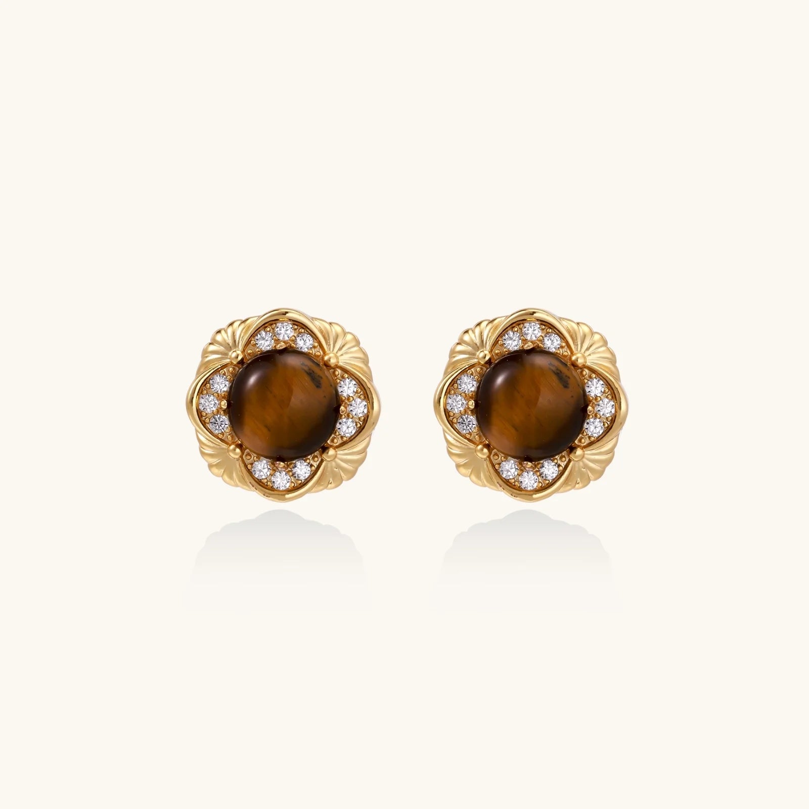 Gold-plated stud earrings with ornate floral frames surrounding cabochon tiger's eye stones and zirconia accents