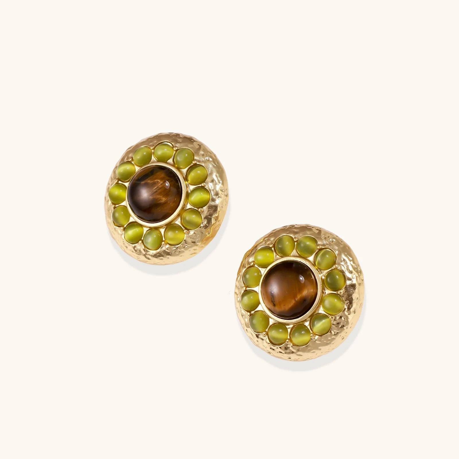 Round hammered gold studs with brown tiger's eye center surrounded by olive green liuli stones on white background.